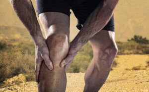 A cropped shot of a man holding his knee because of a defective orthopedic implant