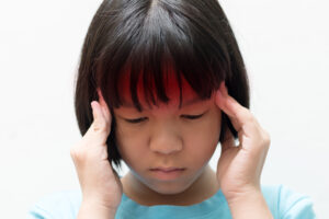 A child holding her head after a brain injury in Atlanta